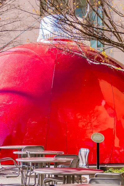 Gigante bauble vermelho na cidade plaza atrás comendo área de mesa — Fotografia de Stock