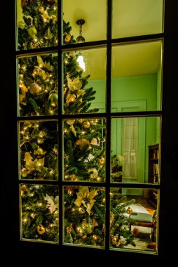 christmas tree in living room viewing thru a window clipart