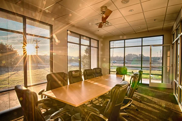 Goed verlichte conferentiezaal met stralen van de zon schijnt door — Stockfoto