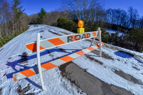 Blocco stradale allestito prima della strada innevata e ghiacciata in montagna — Foto Stock