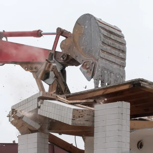 Wreck excavator at work demolishing a building wall — Stock Photo, Image