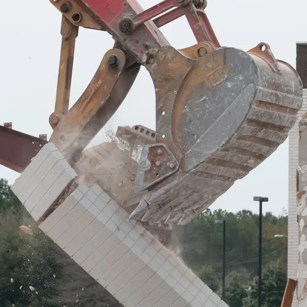 Wrak graafmachine op het werk een gebouw muur af te breken — Stockfoto