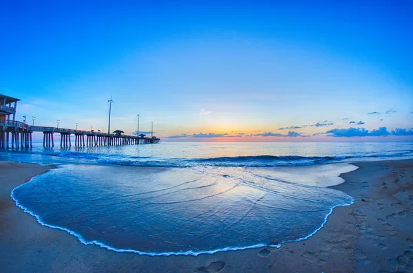 The rising sun peeks through clouds and is reflected in waves by — Stock Photo, Image