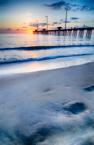 The rising sun peeks through clouds and is reflected in waves by — Stock Photo, Image