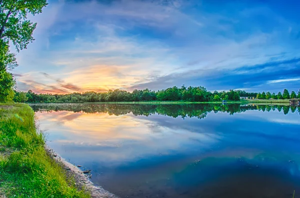 Закат солнца над зеркальным озером — стоковое фото