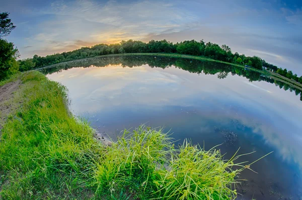 Sun setting over a reflective lake — Stock Photo, Image