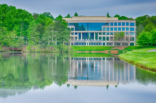 Edificio de oficinas reflejándose en el lago — Foto de Stock