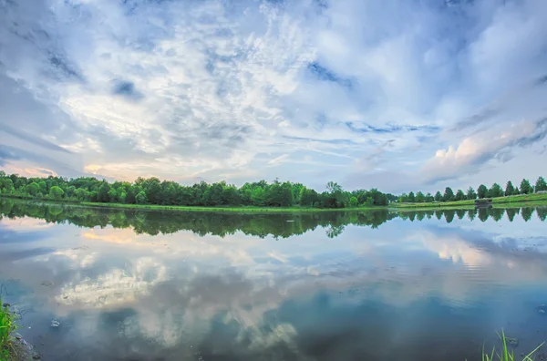 Sun setting over a reflective lake — Stock Photo, Image