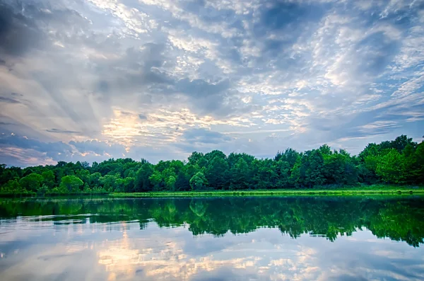 Sun setting over a reflective lake — Stock Photo, Image