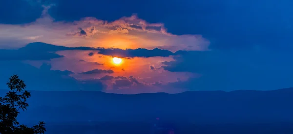 Orange sunset sky and clouds over mountain valley — Stock Photo, Image