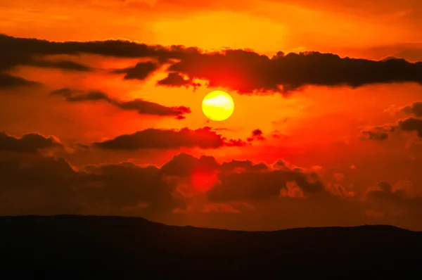 Orange sunset sky and clouds over mountain valley — Stock Photo, Image