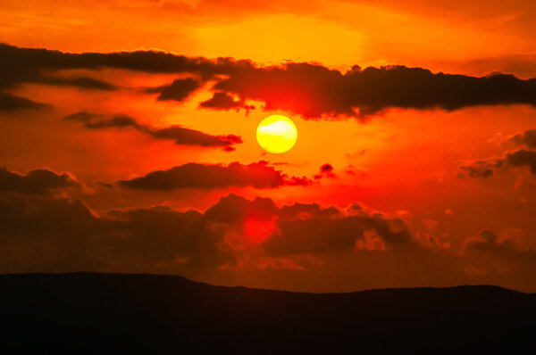 orange sunset sky and clouds over mountain valley