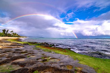 Rainbow over the popular surfing place Sunset Beach , Oahu, Hawaii