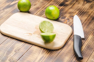 Tahta bir masada dilimlenmiş limon ve bıçaklı beyaz bir bıçak.. 