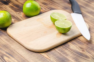 Tahta bir masada dilimlenmiş limon ve bıçaklı beyaz bir bıçak.. 