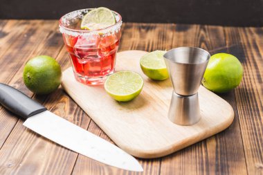 Ahşap masada malzeme ve limon üreten kırmızı kokteyl. Seçici odak