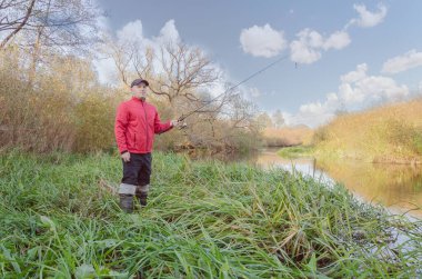 Balıkçı sporcu, oltayı nehre atıyor. Spor balıkçılığı.