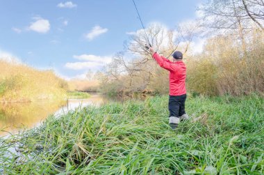 Balıkçı nehre bir olta atar. Spor balıkçılığı.