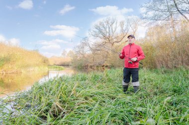 Balıkçı oltasını nehre atıyor. Sanny Day 'de balık avı. 