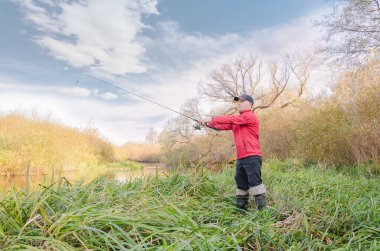 Balıkçı sporcu, oltayı nehre atıyor. Spor balıkçılığı.