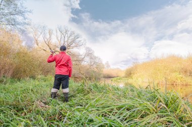 Balıkçı nehre bir olta atar. Spor balıkçılığı.