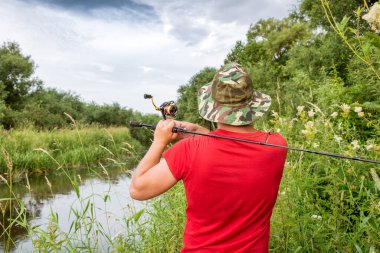 Elinde olta olan bir balıkçı. Arkadan bak..