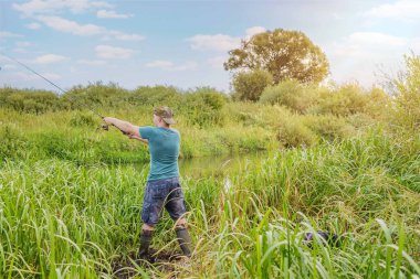 Balıkçı olta atıyor. Nehirde yaz balıkçılığı.