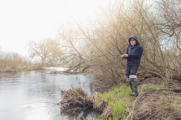 漁師は川に立つ回転棒で魚を引っ張る 男性趣味 — ストック写真