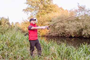 Nehirde spor balıkçılığı. Balıkçı topu fırlatıyor..