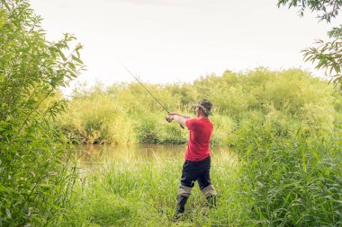 Balıkçı arkadan dönen bir bakış atıyor. Yaz balıkçılık.