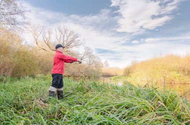 Balıkçı oltasını nehre atıyor. Sanny Day 'de balık avı. 