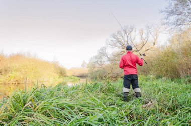 Balıkçı oltasını nehre atıyor. Sanny Day 'de balık avı. 