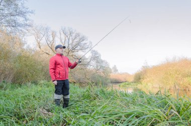 Balıkçı sporcu, oltayı nehre atıyor. Spor balıkçılığı.