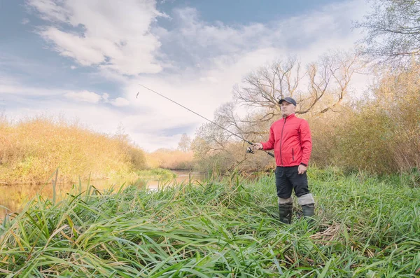Balıkçı nehre bir olta atar. Spor balıkçılığı.
