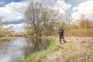 Balıkçılar kıyıya, gökyüzünün arka planına doğru bulutlu bir çubuk fırlatıyor..