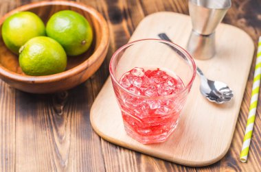 Ahşap bir masada kokteyl hazırlıyorum. İçkiyi bardakta buzla karıştırmak. Üst görünüm