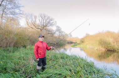 Balıkçı oltasını nehre atıyor. Sanny Day 'de balık avı. 