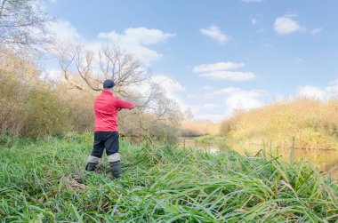 Balıkçı nehre bir olta atar. Arkadan bak.. 