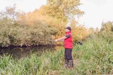 Nehirde spor balıkçılığı. Balıkçı topu fırlatıyor..