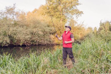 Nehirde spor balıkçılığı. Balıkçı topu fırlatıyor..