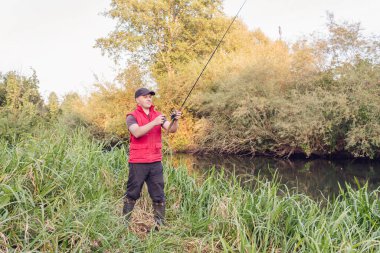 Nehirde spor balıkçılığı. Balıkçı topu fırlatıyor..