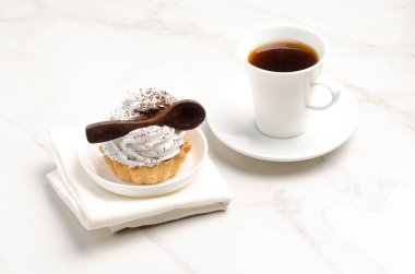 Sütlü beyaz proteinli kek sepeti beyaz bir tabakta çikolata kaşığı ve bir fincan kahveyle süslenmiş. Tatlı teması. 