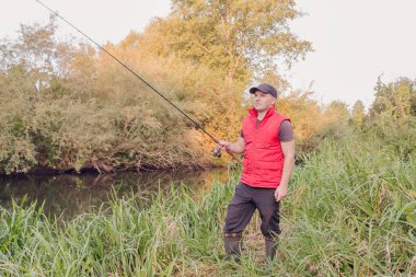 Nehirde spor balıkçılığı. Balıkçı topu fırlatıyor..