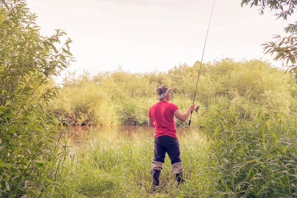 漁師は後ろから回転する景色を投げます 夏の釣り — ストック写真