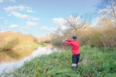 Balıkçı sporcu, oltayı nehre atıyor. Spor balıkçılığı.