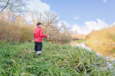 Balıkçı nehre bir olta atar. Arkadan bak.. 