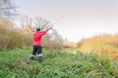 Balıkçı nehre bir olta atar. Arkadan bak.. 