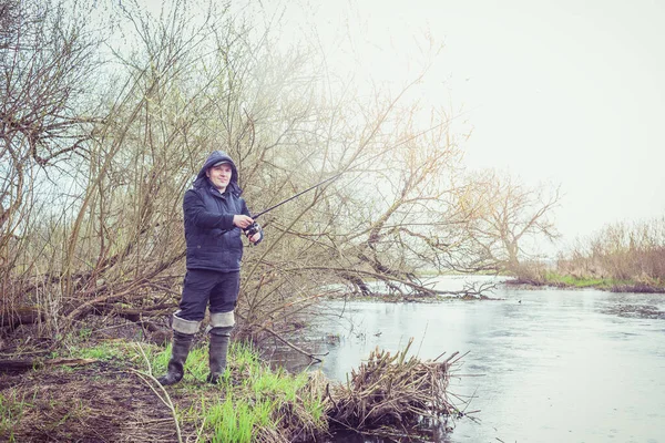 Uomo Pesca Sulla Riva Del Fiume Sotto Pioggia — Foto Stock