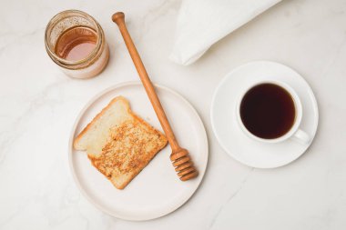Kahvaltıda ballı kızarmış ekmek ve beyaz arka planda kahve. Üst görünüm.