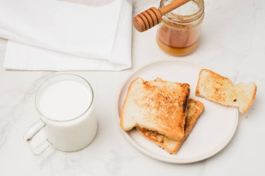 Kahvaltı için beyaz arka planda ballı ve sütlü kızarmış ekmek. Üst görünüm.